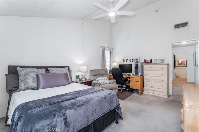 bedroom with ceiling fan, high vaulted ceiling, and light carpet