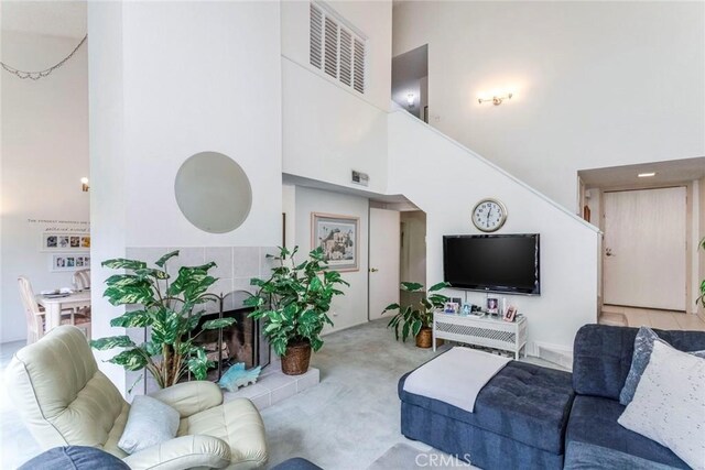 carpeted living room with a towering ceiling