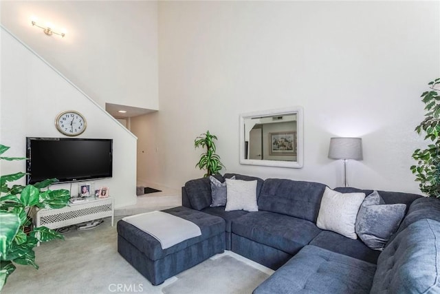 living room featuring carpet and a high ceiling