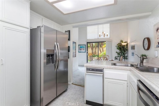 kitchen featuring white cabinets, appliances with stainless steel finishes, kitchen peninsula, and sink