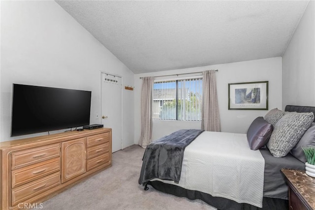 bedroom with light carpet, a textured ceiling, and lofted ceiling