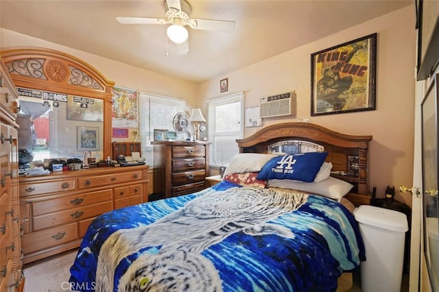 bedroom with a wall unit AC and ceiling fan