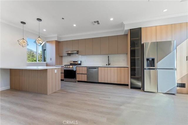 kitchen featuring crown molding, light hardwood / wood-style flooring, hanging light fixtures, and appliances with stainless steel finishes