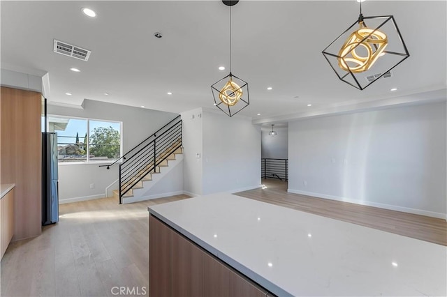 kitchen featuring decorative light fixtures and light hardwood / wood-style flooring