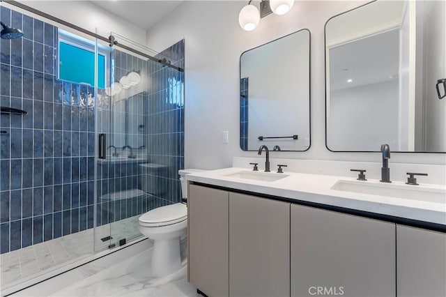 bathroom featuring vanity, toilet, and a shower with door