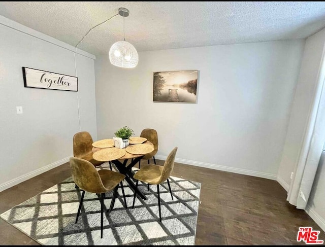 dining space featuring a textured ceiling and dark hardwood / wood-style flooring