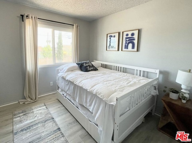 bedroom featuring a textured ceiling and light wood-type flooring