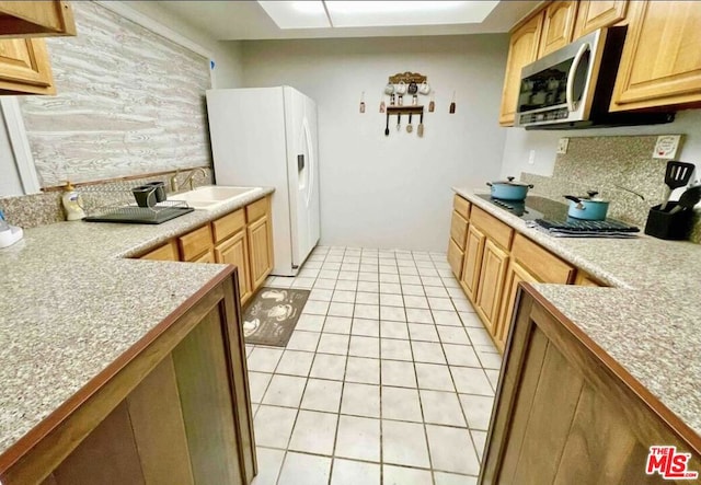 kitchen with tasteful backsplash, appliances with stainless steel finishes, sink, and light tile patterned flooring