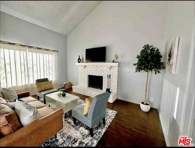 living room featuring a brick fireplace, a textured ceiling, high vaulted ceiling, and dark hardwood / wood-style flooring