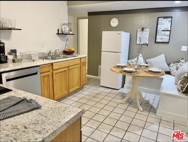 kitchen featuring sink, dishwasher, light tile patterned flooring, and white refrigerator