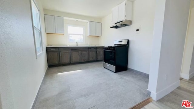 kitchen with stainless steel range with gas stovetop, white cabinets, and dark brown cabinetry