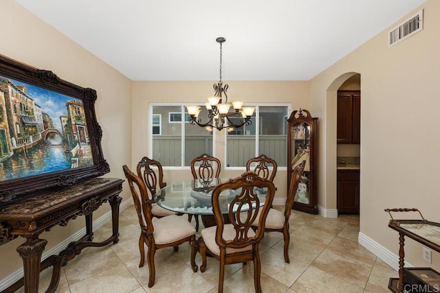 tiled dining area featuring an inviting chandelier