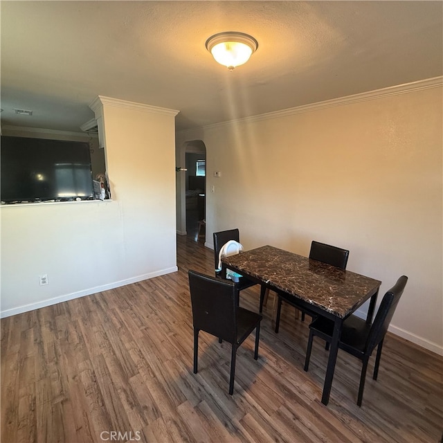 dining space with ornamental molding and hardwood / wood-style floors