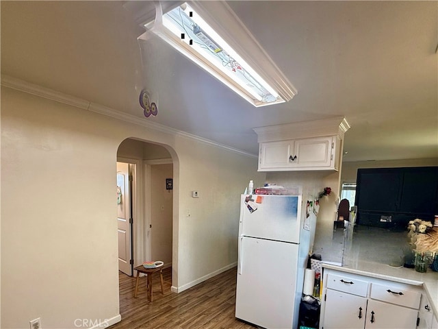 kitchen with ornamental molding, white cabinetry, hardwood / wood-style flooring, and white refrigerator