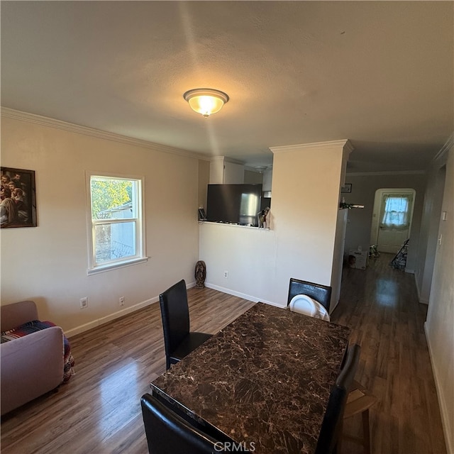 dining room with ornamental molding and dark hardwood / wood-style flooring