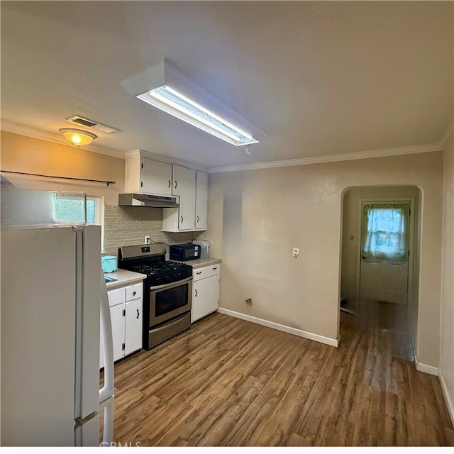 kitchen featuring gas stove, white cabinetry, light wood-type flooring, crown molding, and white refrigerator