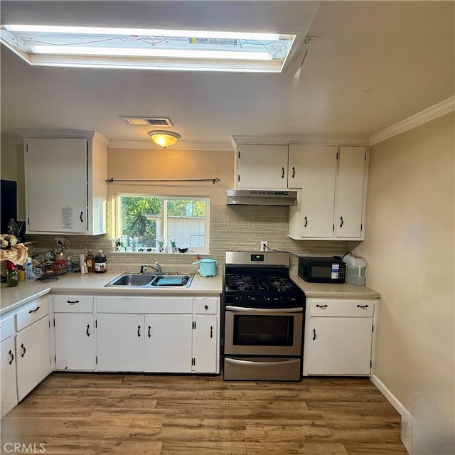 kitchen featuring sink, crown molding, stainless steel gas range oven, white cabinets, and light hardwood / wood-style floors