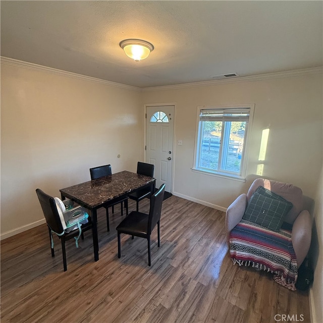 dining space featuring wood-type flooring and ornamental molding