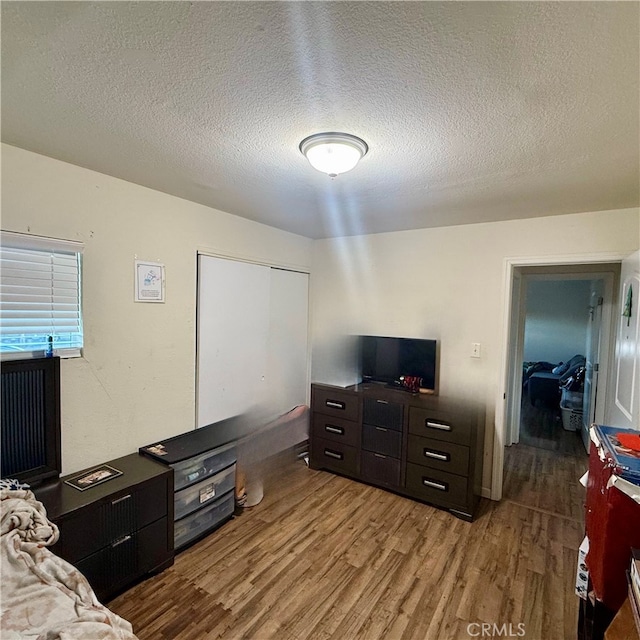 bedroom featuring a closet, a textured ceiling, and light wood-type flooring