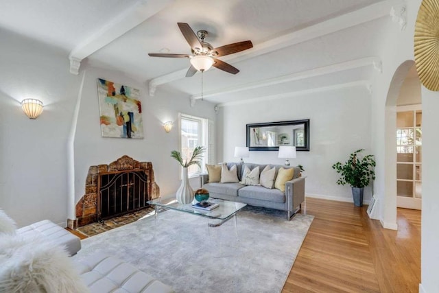 living room with beam ceiling, ceiling fan, and wood-type flooring