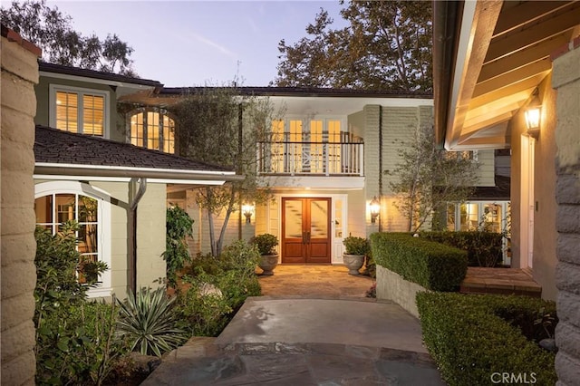3 Cypress Point Ln, Newport Beach, CA 92660 - exterior entry at dusk with a balcony and french doors