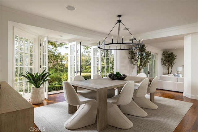 dining space with crown molding, a notable chandelier, and dark hardwood / wood-style floors