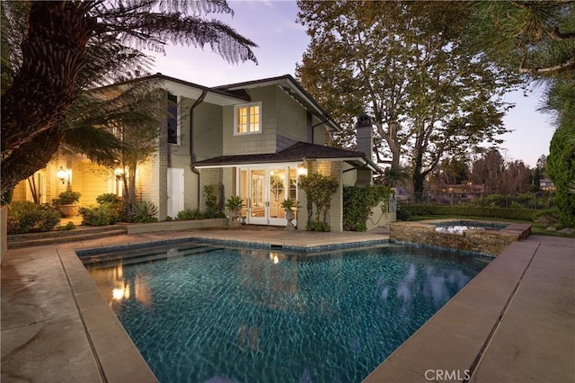 3 Cypress Point Ln, Newport Beach, CA 92660 - pool at dusk with french doors, a patio, and a pool with connected hot tub