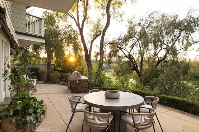 view of patio with area for grilling and a balcony