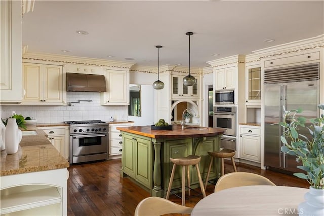3 Cypress Point Ln, Newport Beach, CA 92660 - kitchen featuring built in appliances, under cabinet range hood, butcher block countertops, a center island with sink, and dark wood-style flooring