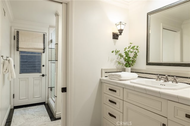 bathroom with vanity, ornamental molding, and a shower with door