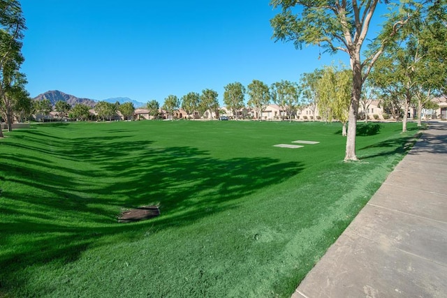 surrounding community with a lawn and a mountain view