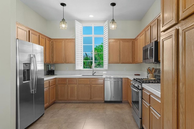 kitchen with sink, light tile patterned floors, stainless steel appliances, and hanging light fixtures