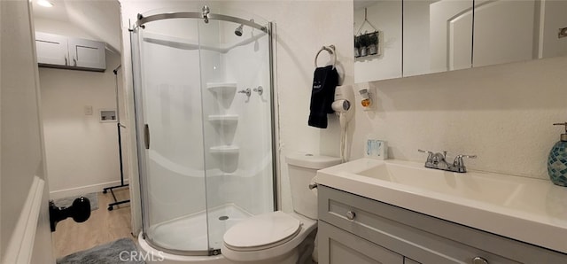 bathroom with vanity, toilet, and a shower with door