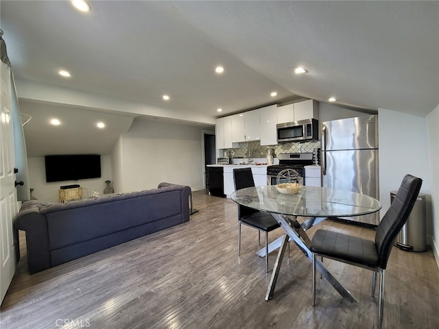 dining area featuring lofted ceiling and light hardwood / wood-style flooring