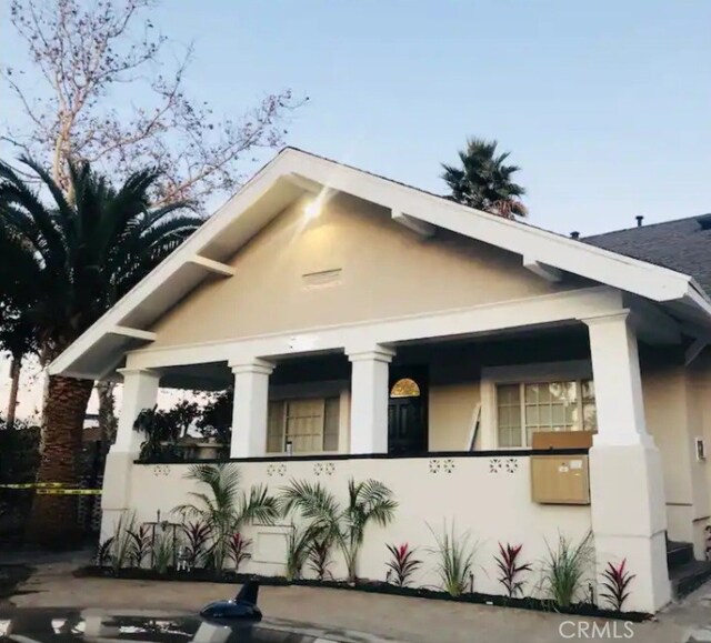 view of side of property featuring covered porch