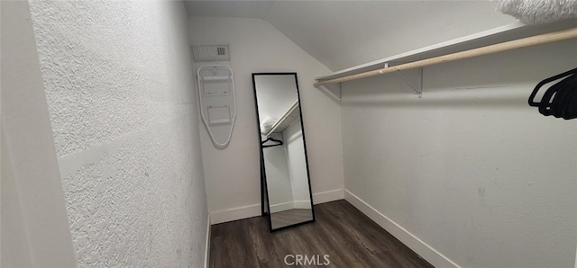 spacious closet with vaulted ceiling and dark hardwood / wood-style floors