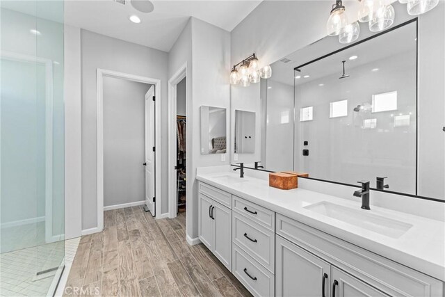 bathroom with hardwood / wood-style flooring, vanity, and a shower