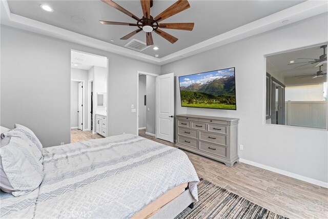 bedroom with ceiling fan, ensuite bathroom, and light hardwood / wood-style floors