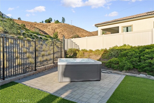 view of patio / terrace featuring a mountain view and a hot tub