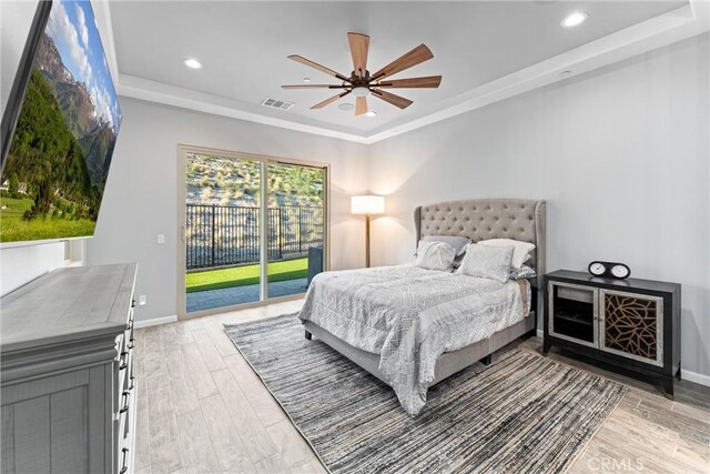 bedroom with access to outside, a raised ceiling, ceiling fan, and wood-type flooring