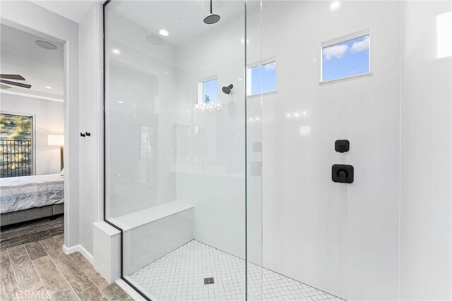 bathroom featuring tiled shower, hardwood / wood-style flooring, and ceiling fan