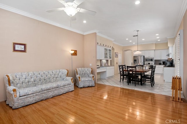 living room featuring ceiling fan, light hardwood / wood-style flooring, and ornamental molding