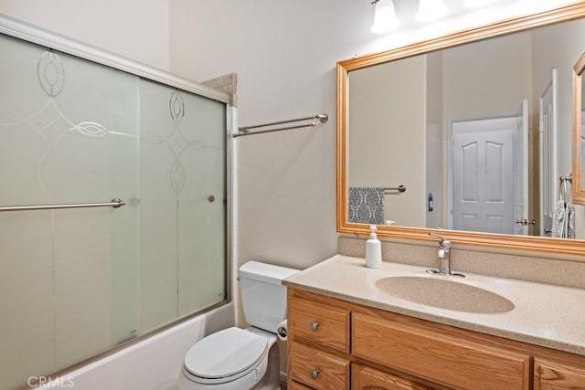 full bathroom with vanity, enclosed tub / shower combo, and toilet