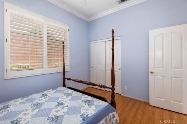 bedroom with crown molding, a closet, ceiling fan, and light hardwood / wood-style floors