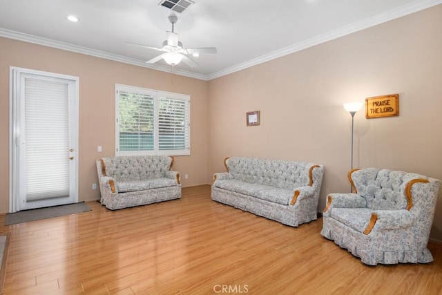 living room featuring hardwood / wood-style floors, ceiling fan, and crown molding