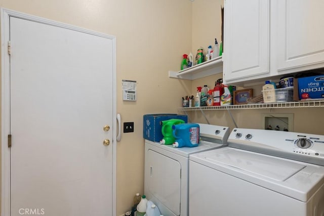 washroom with washer and dryer and cabinets