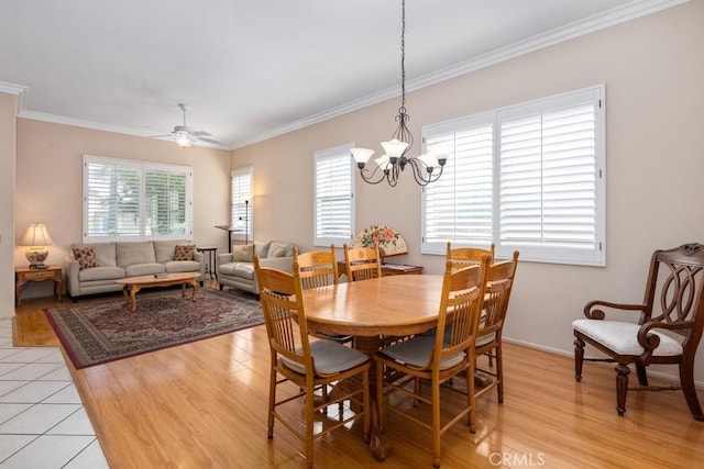 dining room with ceiling fan with notable chandelier, a healthy amount of sunlight, and light hardwood / wood-style flooring