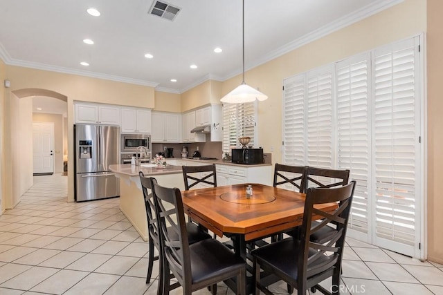 tiled dining area featuring crown molding