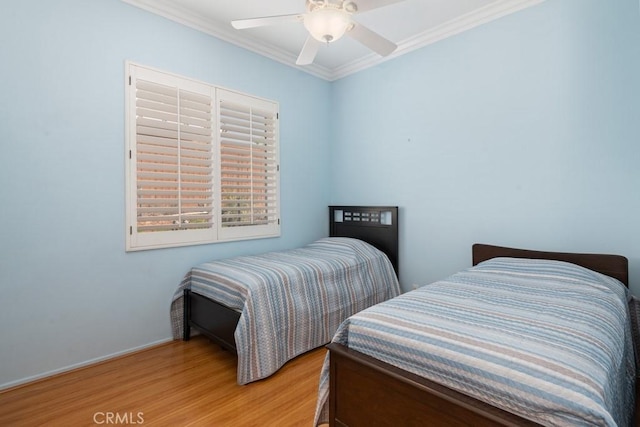 bedroom with light wood-type flooring, ceiling fan, and crown molding