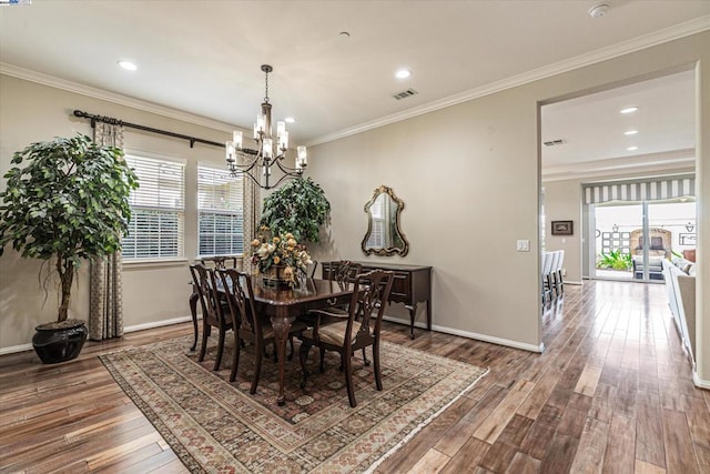 dining area featuring hardwood / wood-style floors, a notable chandelier, and ornamental molding